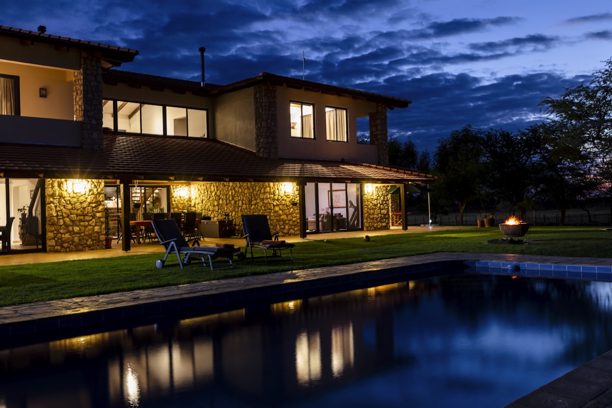 Luxury villa exterior at night with security lighting