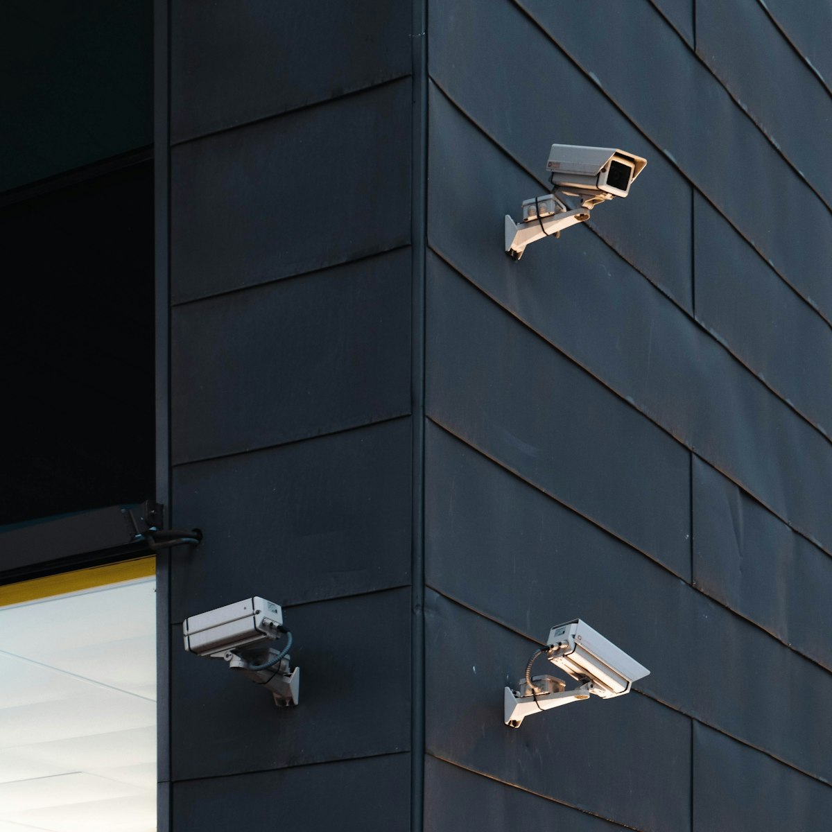 Modern CCTV security cameras on a dark contemporary facade