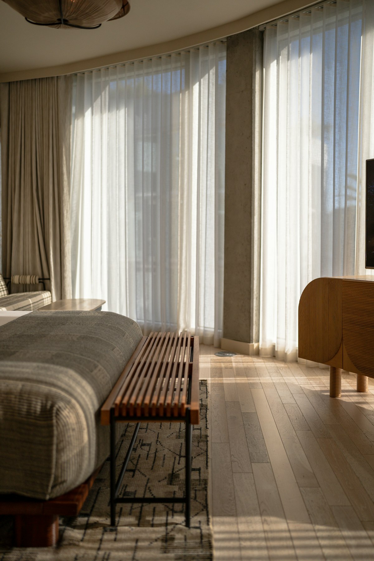 Bright bedroom with morning sunlight through open curtains